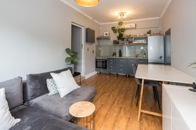 a living room with a couch and a table at Beautiful garden flat in Cape Town