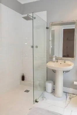a bathroom with a sink and a glass shower at Beautiful garden flat in Cape Town