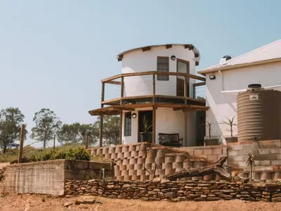 a house with a tower on top of a building at Dassenheuwel Farm Stay Cottages in Malmesbury