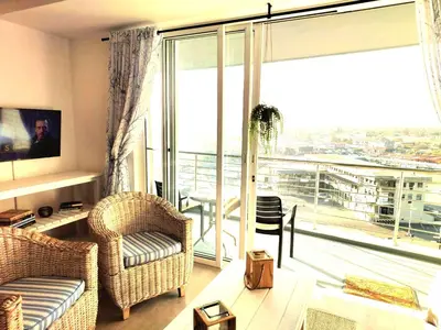 a living room with a couch and chairs and a large window at 404 Horizon Bay in Bloubergstrand