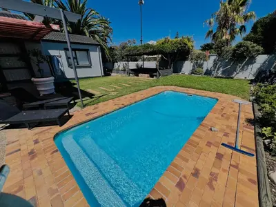 a swimming pool in the backyard of a house at Private garden guest house in Cape Town