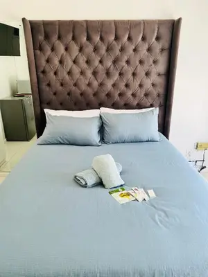 a bed with two pillows and two towels on it at Private garden guest house in Cape Town