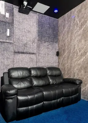 a black leather couch in a room with a stone wall at FB-Canatal Luxury Apartments in Cape Town