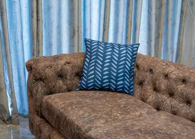 a brown couch with a blue pillow on it at FB-Canatal Luxury Apartments in Cape Town