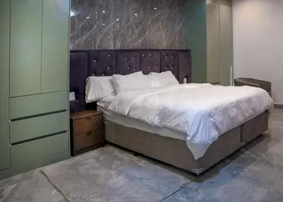a bedroom with a large bed with a wooden headboard at FB-Canatal Luxury Apartments in Cape Town