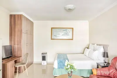 a hotel room with a bed and a tv at Goodwood Oasis Free WiFi-Parking 2 in Cape Town