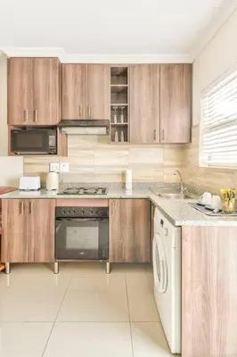 a kitchen with wooden cabinets and a dishwasher at Goodwood Oasis Free WiFi-Parking 2 in Cape Town