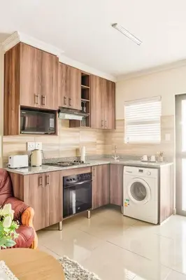 a kitchen with a washer and dryer in a room at Goodwood Oasis Free WiFi-Parking 2 in Cape Town