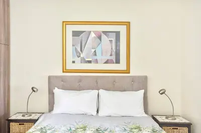 a bed with two lamps and a picture above it at Goodwood Oasis FreeWiFi-Parking 1 in Cape Town