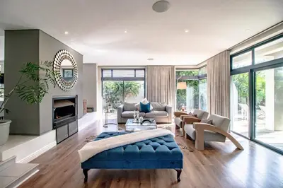 a living room with a blue couch and a fireplace at Bayhill Terrace 17 by CTHA in Cape Town