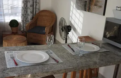 a table with two plates and wine glasses on it at The Somerset nest in Cape Town