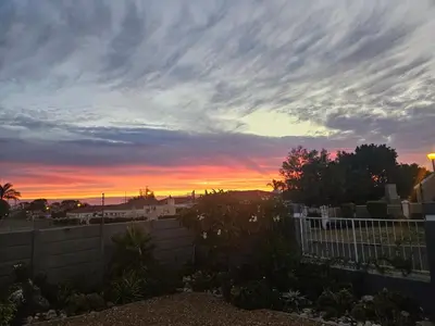a sunset over a backyard with a fence in front of a fence at The Somerset nest in Cape Town