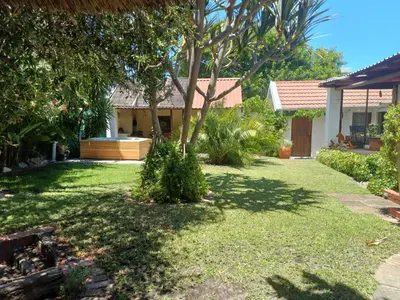 a yard with a house with a tree in it at Garden City Summer in Cape Town