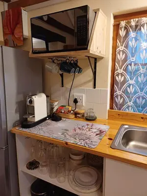 a kitchen counter with a microwave and a sink at Garden City Summer in Cape Town