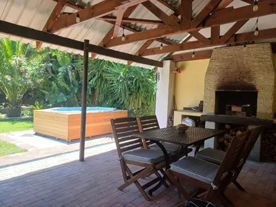 a patio with a table and chairs and a hot tub at Garden City Summer in Cape Town