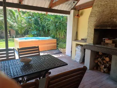 a patio with a table and a fireplace at Garden City Summer in Cape Town
