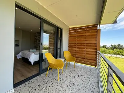 two chairs on the balcony of a house at Swanemeer Apartments in Cape Town