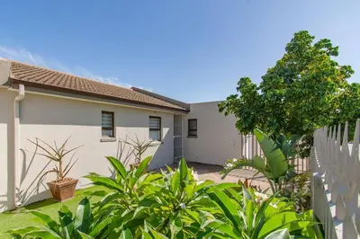 a house with a fence and plants in front of it at Chic, Cozy, Modern, Secure and Centrally Located in Cape Town
