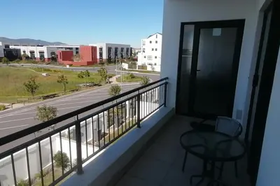 a balcony with a table and a view of a street at Sundown Apartment in Cape Town