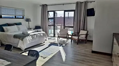 a bedroom with a large bed and a large window at Hermanus reefs in Hermanus