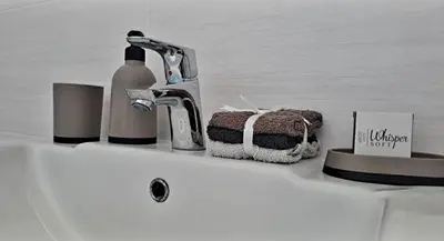 a bathroom sink with a bottle of soap and a towel at Hermanus reefs in Hermanus