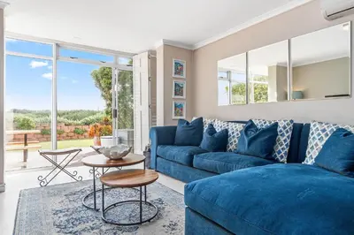 a living room with a blue couch and a table at Neptune Isle 9 in Cape Town