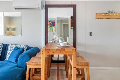 a living room with a blue couch and a wooden table at Neptune Isle 9 in Cape Town