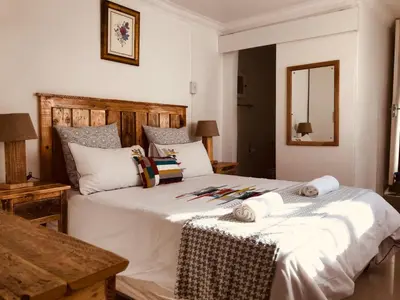 a bedroom with a large white bed with a mirror at MELJAA GROUP Guesthouse in Cape Town