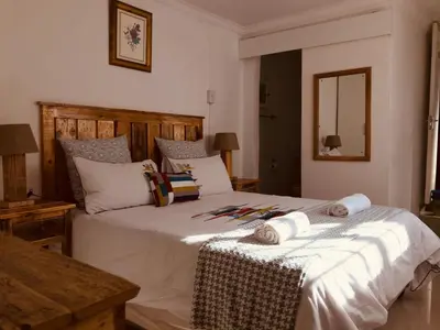 a bedroom with a large bed with towels on it at MELJAA GROUP Guesthouse in Cape Town