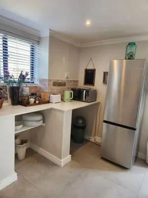 a kitchen with a stainless steel refrigerator in it at Haus Merwe Self Catering in Cape Town