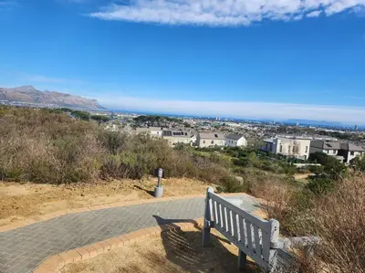 a bench sitting on top of a hill with a view at Haus Merwe Self Catering in Cape Town