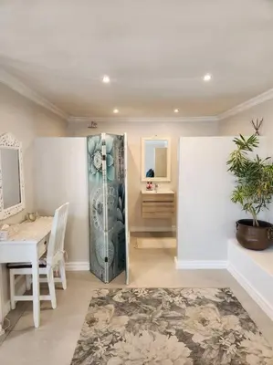 a living room with a table and a room with a desk at Haus Merwe Self Catering in Cape Town