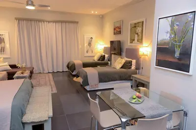 a hotel room with two beds and a living room at Art and Accommodation Guesthouse in Cape Town