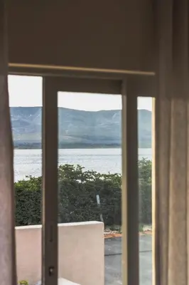 a view of the ocean from a window at Sandown Synergy Lagoon House in Hermanus