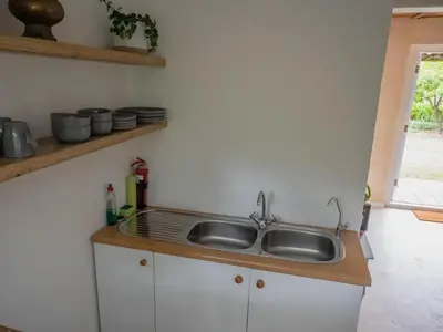 a kitchen counter with a sink and a window at Cape Weaver cottage in Greyton