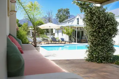 a villa with a swimming pool and a house at Largest one bed apartment & private pool in the Hoek in Franschhoek