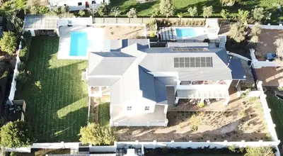 an aerial view of a white house with a pool at Largest one bed apartment & private pool in the Hoek in Franschhoek