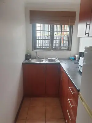 a small kitchen with a sink and a window at Cape Cottage in Cape Town