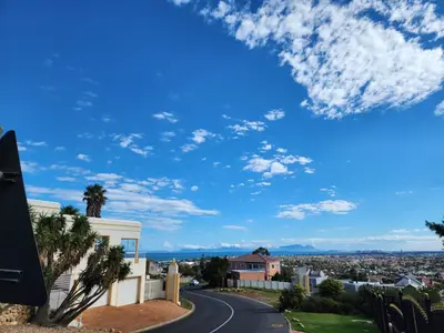 a road in a city with a blue sky at Cape Cottage in Cape Town