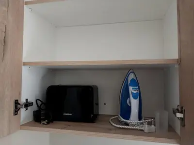 a shelf with a microwave and a surfboard on it at Neptune in Gordonʼs Bay