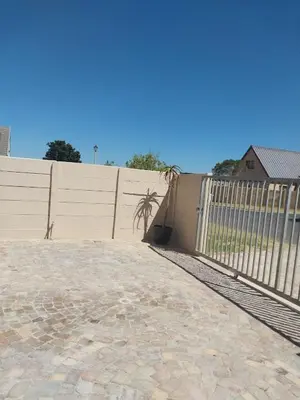 a fence in front of a building with a wall at Neptune in Gordonʼs Bay