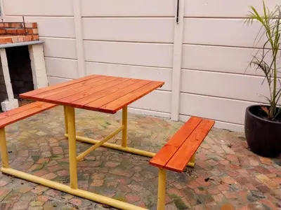 a picnic table and two benches on a brick patio at Neptune in Gordonʼs Bay