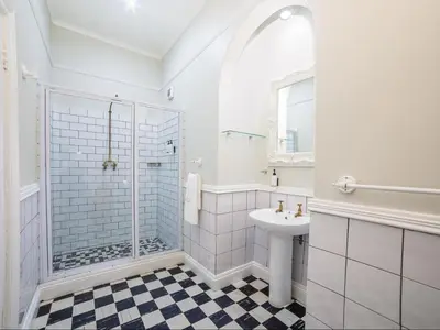 a white bathroom with a shower and a sink at Nantes-vue in Paarl