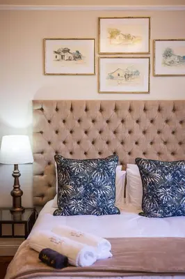 a hotel room with a bed with a large headboard at Nantes-vue in Paarl