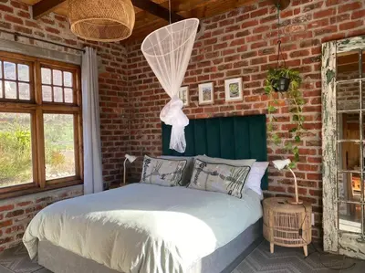 a bedroom with a bed in a brick wall at Underhill Cottage in Breerivier