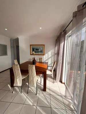a dining room with a wooden table and chairs at 3 Bedroom Family Home with Pool in Cape Town