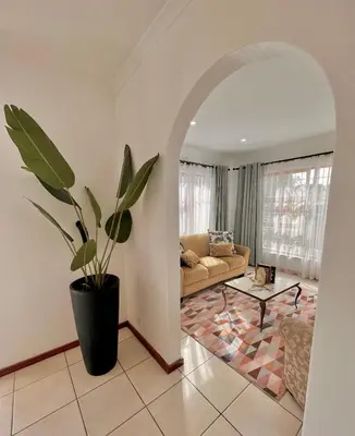 a living room with a couch and a potted plant at 3 Bedroom Family Home with Pool in Cape Town