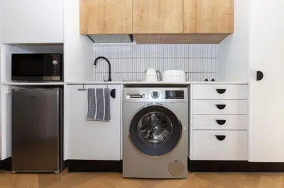 a kitchen with a washing machine and a microwave at Nine Palms 223B in Cape Town