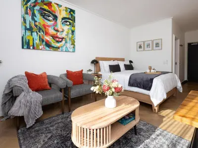 a bedroom with a king sized bed and a couch at Nine Palms 223B in Cape Town