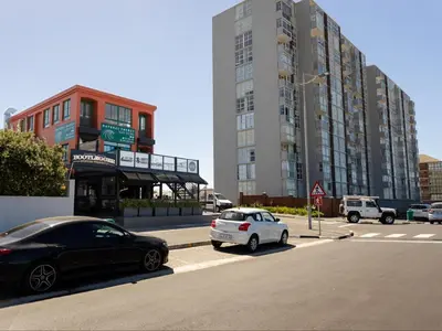 two cars parked on the side of a street with buildings at St Tropez Beachfront 306 in Strand